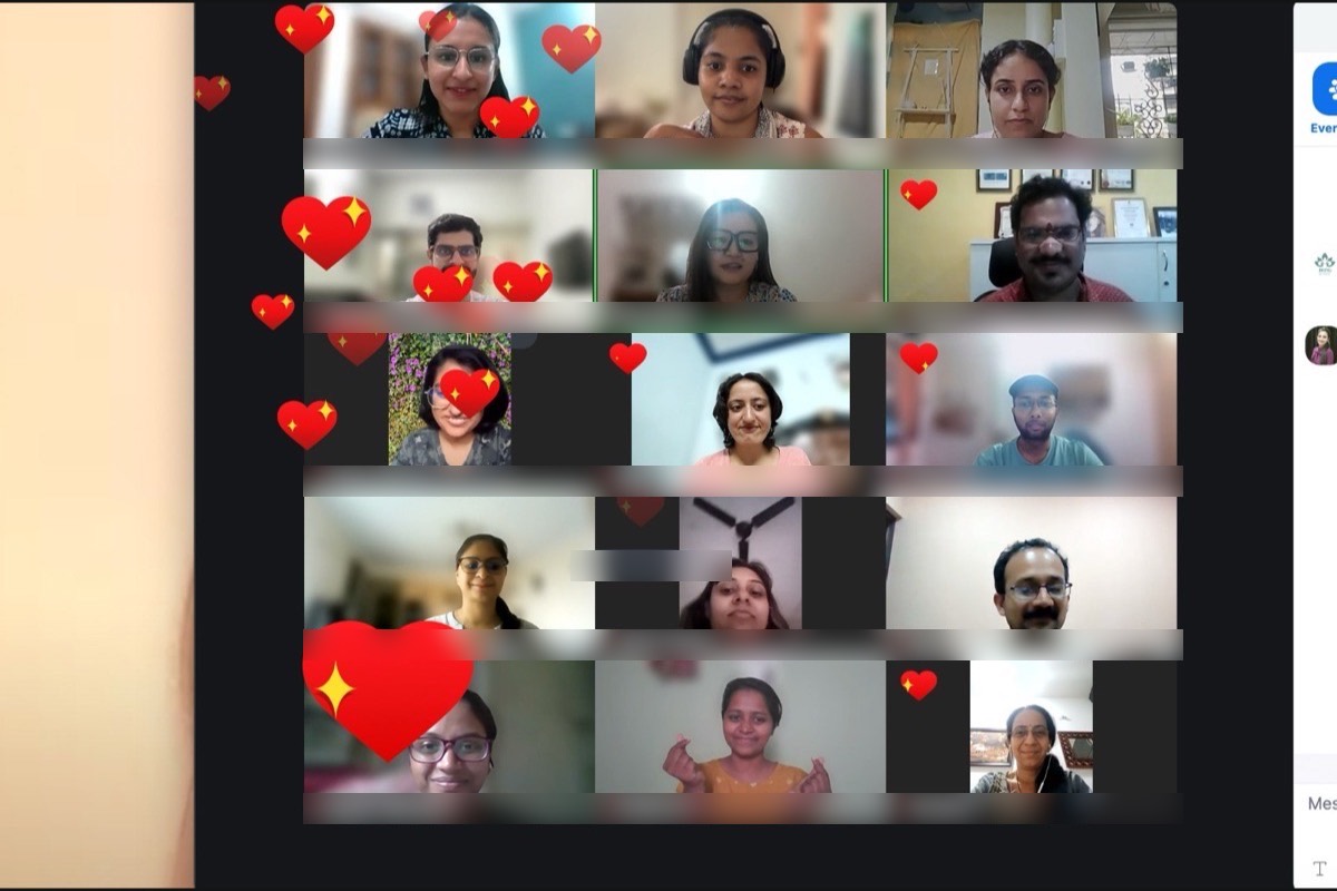 Participants in an online circle with heart reactions floating across the screen